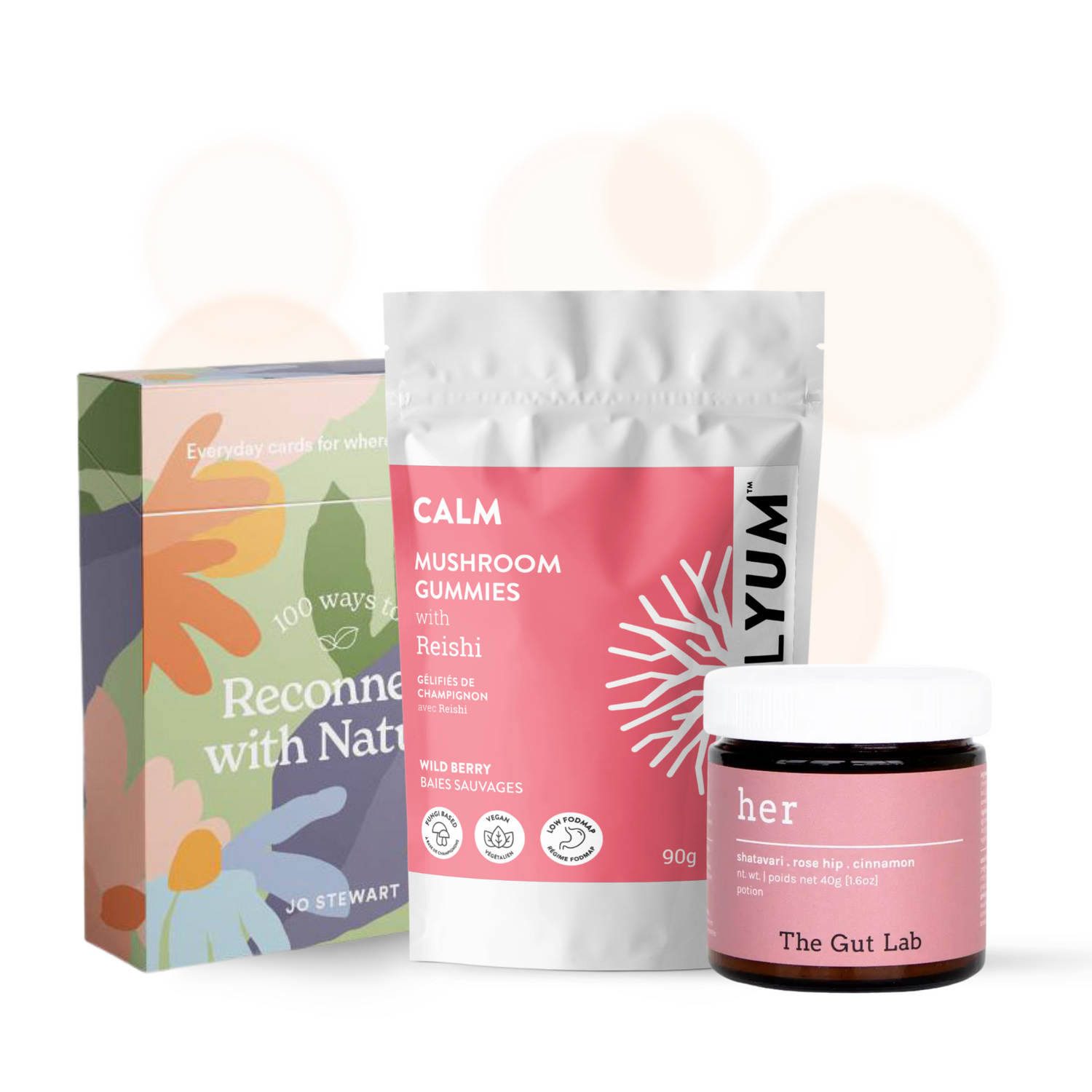 A multi-colored box of Reconnect with Nature flash cards, a pink package of Mycelyum Reishi functional mushroom gummies with a pink jar of Her drink powder by The Gut Lab.